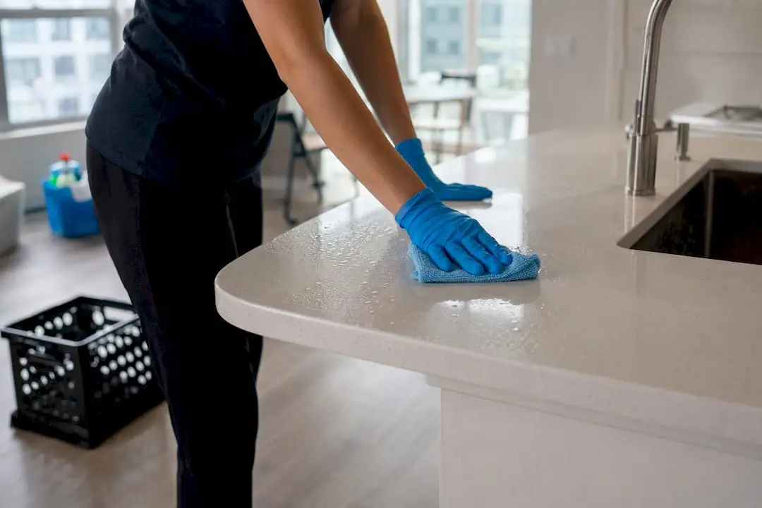 Hands cleaning kitchen surfaces in apartment