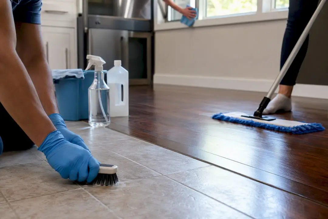 Hands cleaning grout, hardwood floor, window track