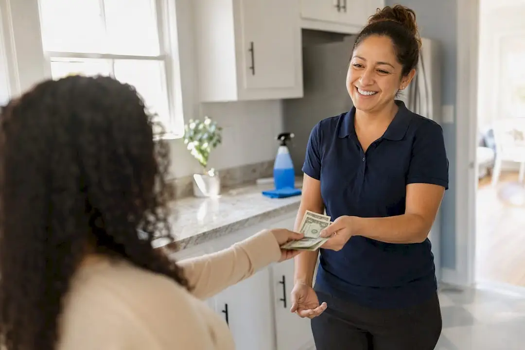 Hand tipping house cleaner cash in home
