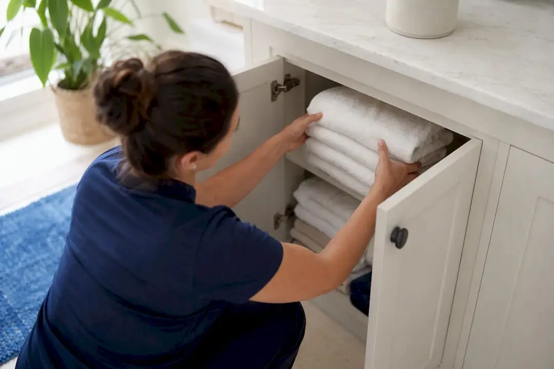 Hands arranging towels in home closet