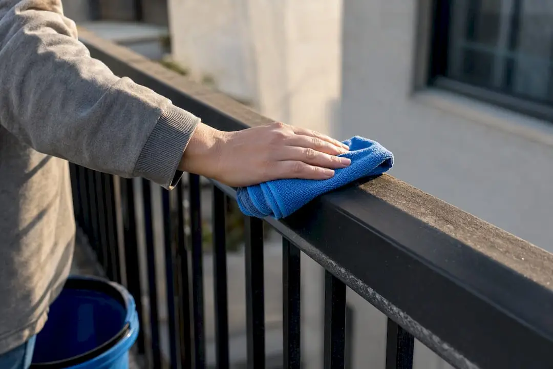 Wiping grime from an apartment balcony rail