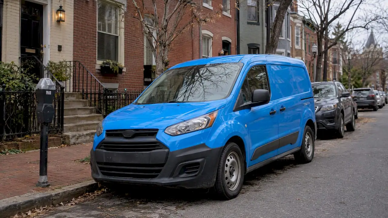 Blue service van parked on a DC rowhouse street